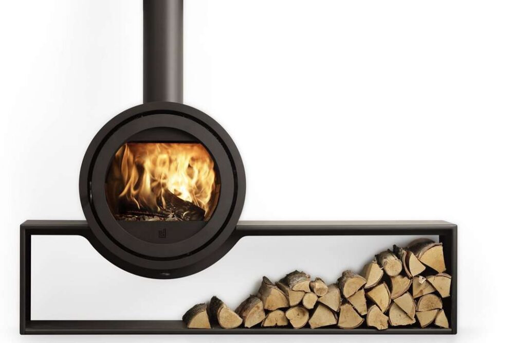 Dik Geurts Odin Tunnel log burner with a stack of firewood beneath.